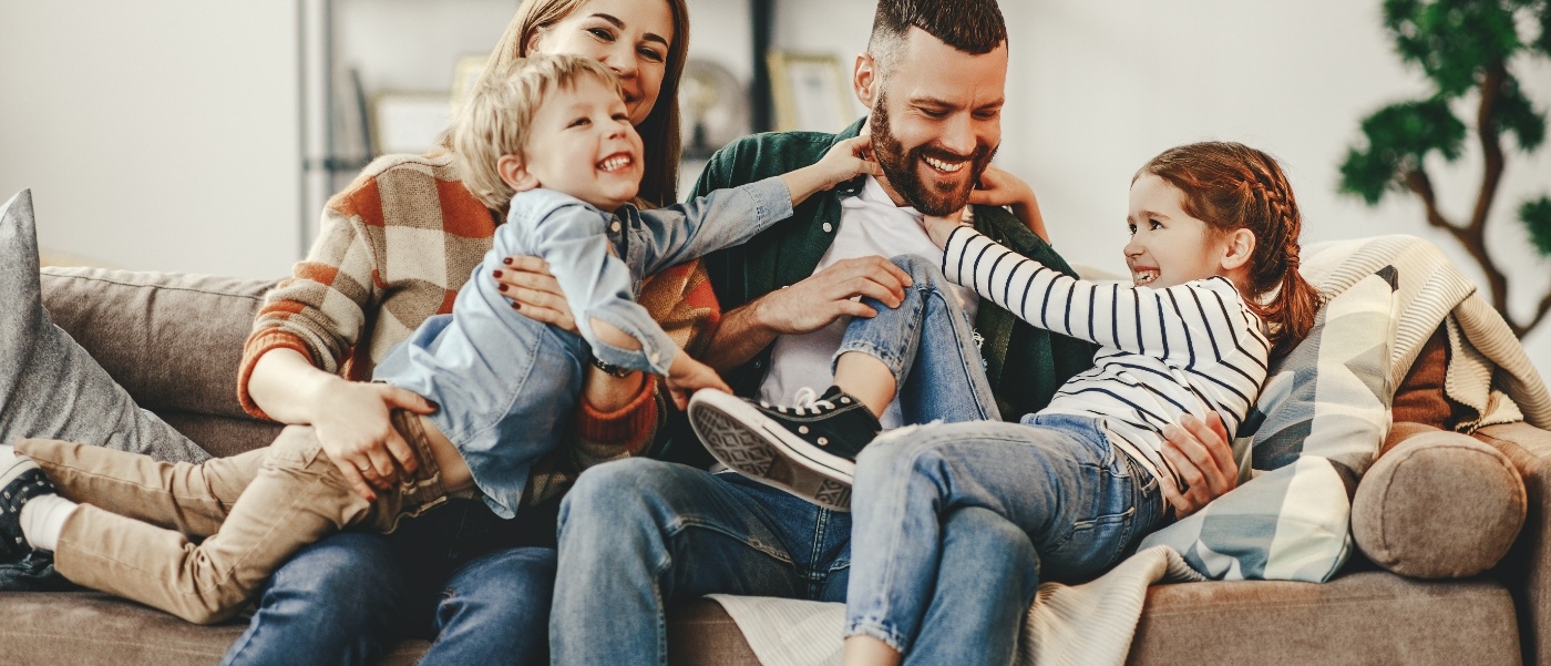 Family of four playing on couch after childrens dentistry visit