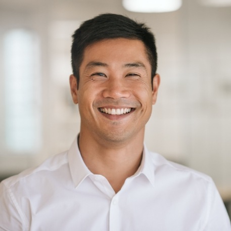 Man in white collared shirt grinning