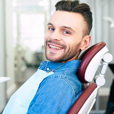 Man smiling while sitting in dental chair