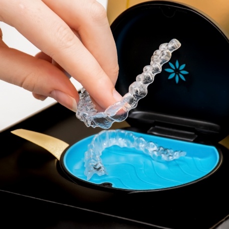 Person placing an Invisalign tray in its storage case