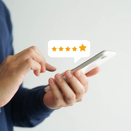 Person typing on phone next to graphic showing five stars